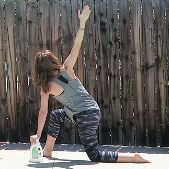 yoga teacher using laundry detergent bottle as a yoga block