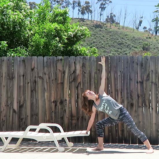Yoga teacher using sun lounger as a yoga block