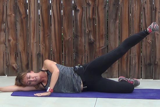 pilates teacher performing side lying leg lift