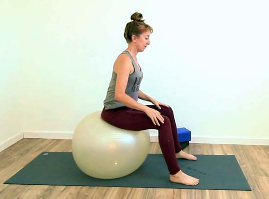 yoga teacher sitting on a stability ball