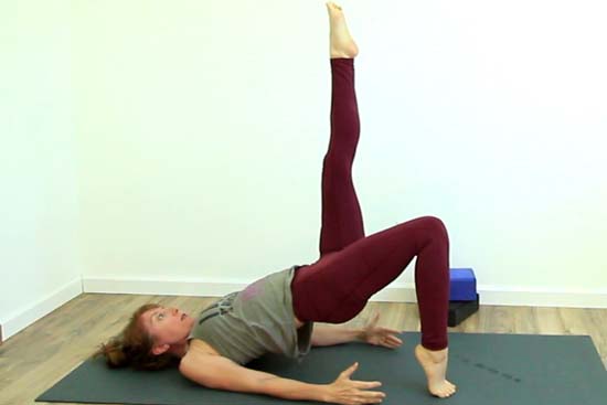 yoga teacher showing single leg bridge on tiptoes