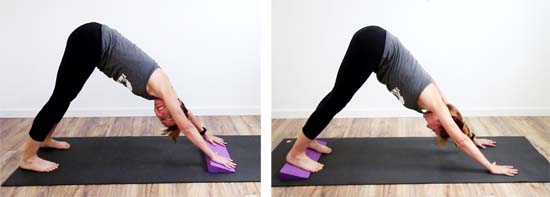 yoga teacher using a wedge in downward dog. Under the hands or under the heels.