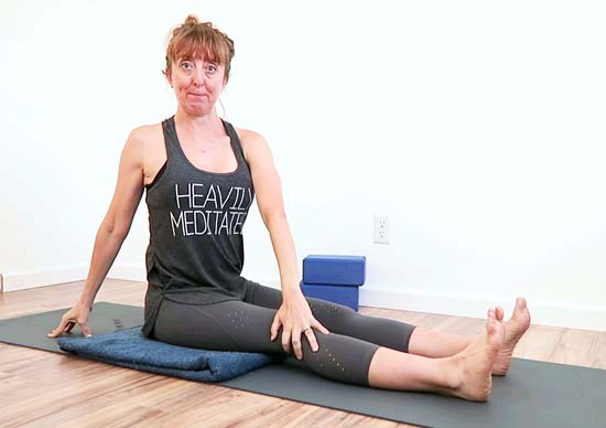 yoga teacher demonstrating Seated spinal twist with fixed pelvis and reduce rotation