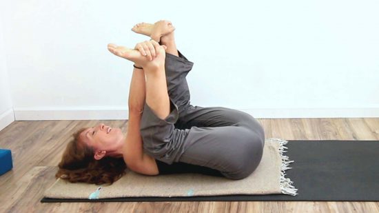 yoga teacher in happy baby pose