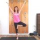 tree pose with arms lifted and eyes closed