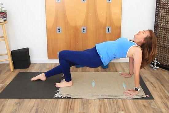 yoga teacher demonstrating reverse plank modification